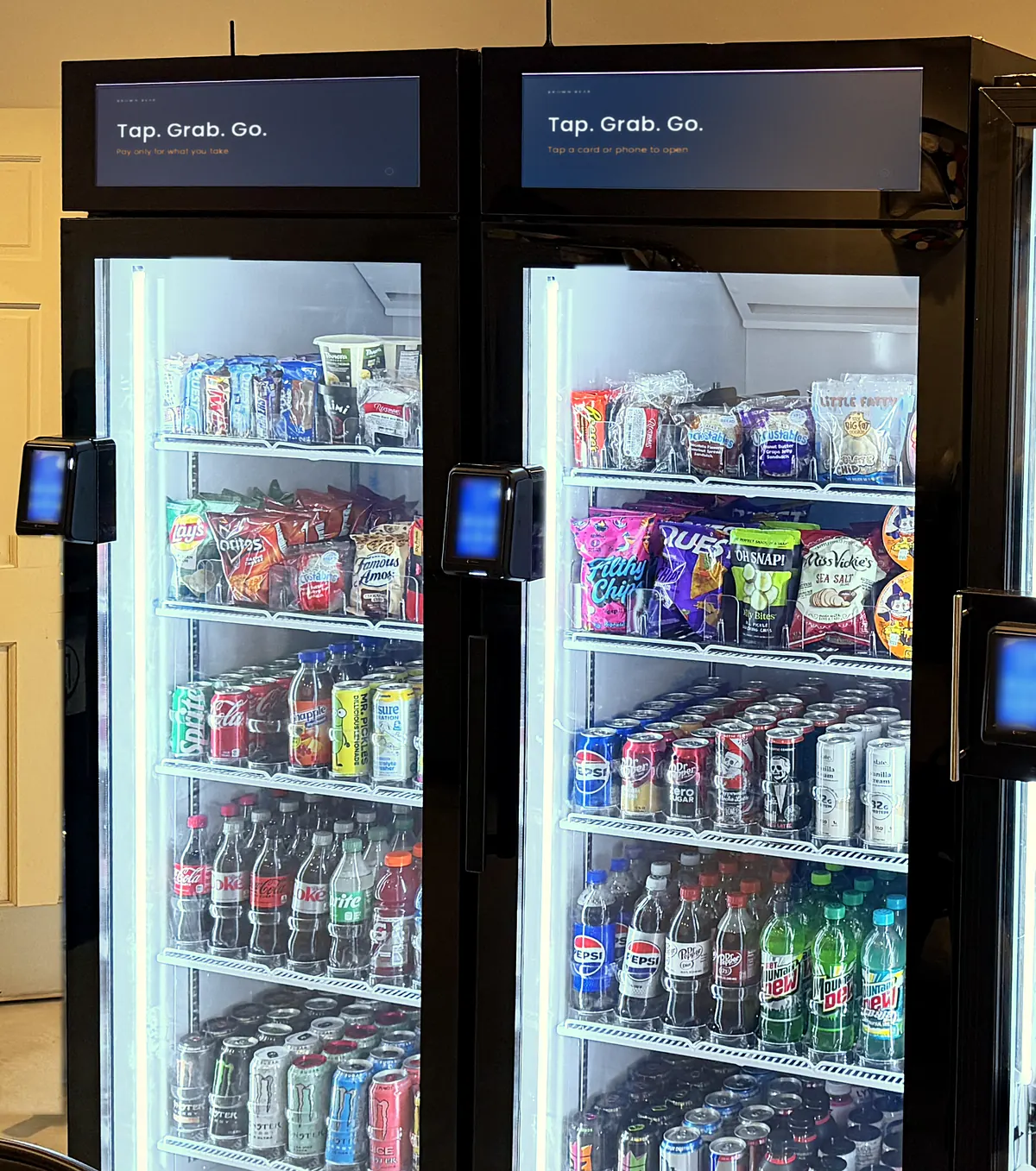 Two Brown Bear glass-door smart coolers, lit and stocked, with tap-to-pay readers on the doors.