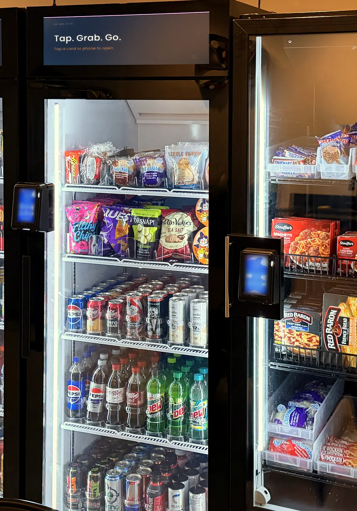 A Brown Bear smart cooler, lit and stocked, with its tap-to-pay reader on the door.