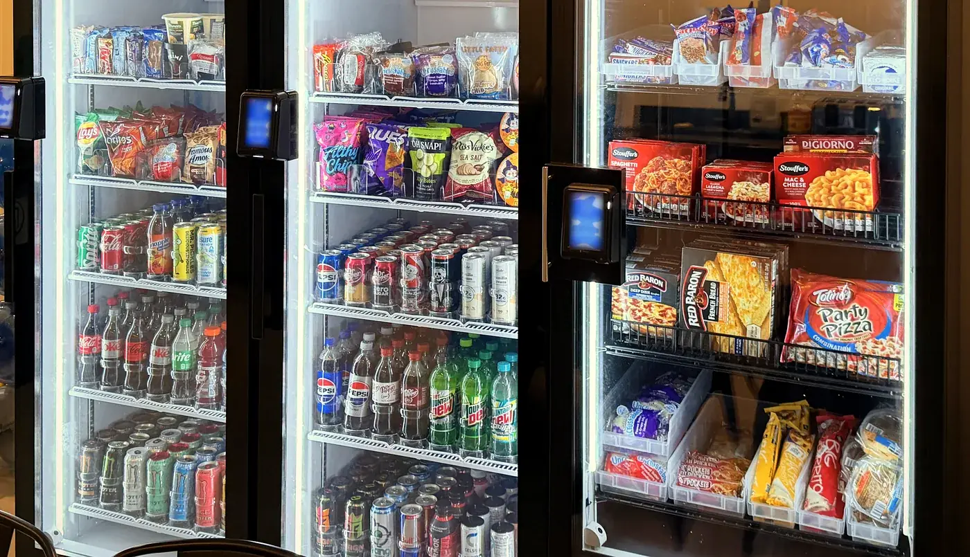 Close-up of stocked shelves in Brown Bear smart coolers: snacks, sodas, energy drinks and frozen meals.